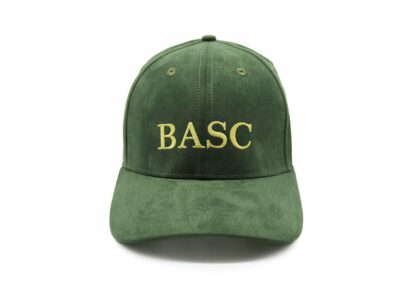 Front view of a green textured BASC cap featuring a gold embroidered BASC logo, displayed on a clean white background.